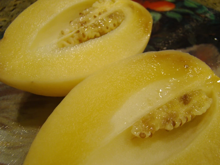 two yellow halves cut open to show a fruit