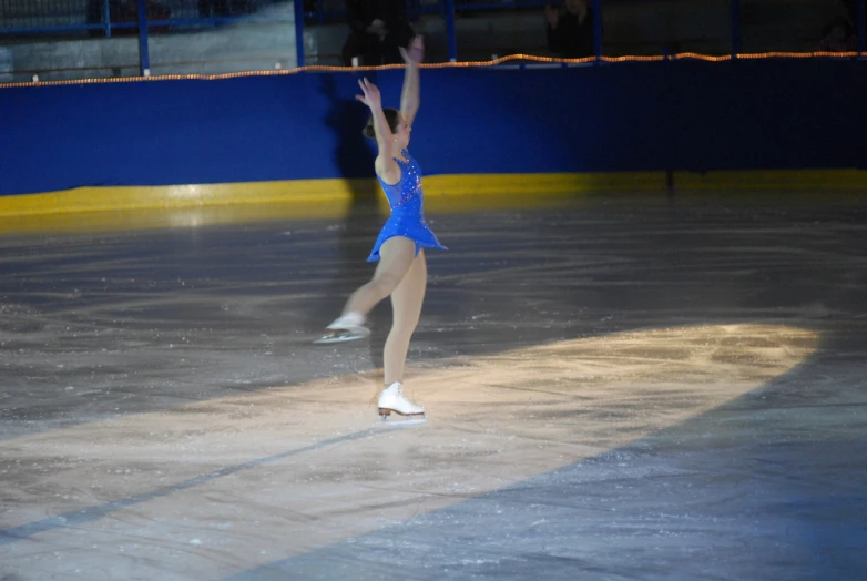 a woman in an ice skate competition, arms above the knee