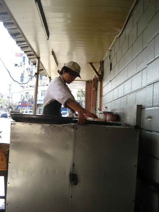 a man in an outdoor kitchen preparing food