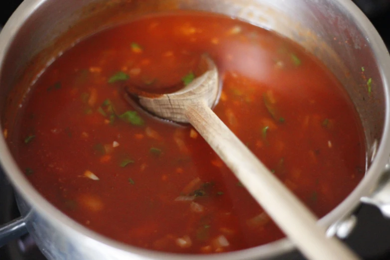 a pot with soup and a wooden spoon