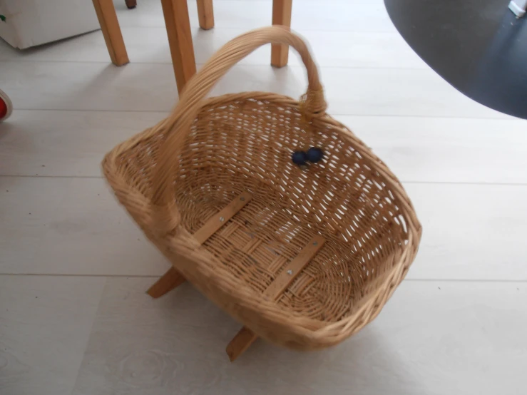 a very big wicker basket by some chairs