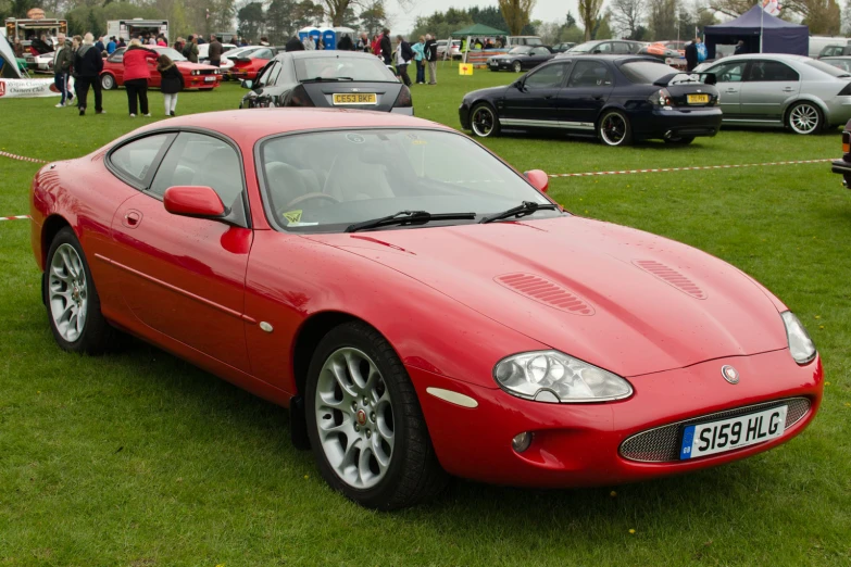 a red car parked on top of green grass