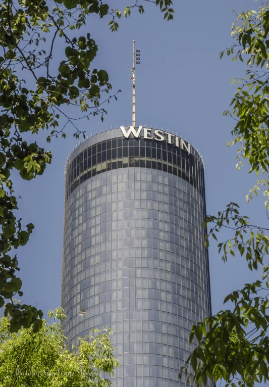 a large glass building sits in the middle of the trees