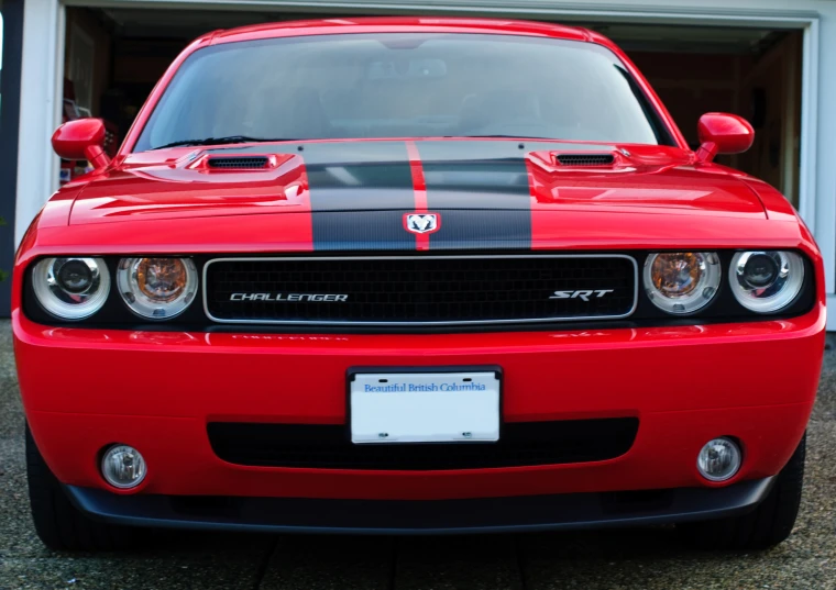 a red sport car parked in front of a garage