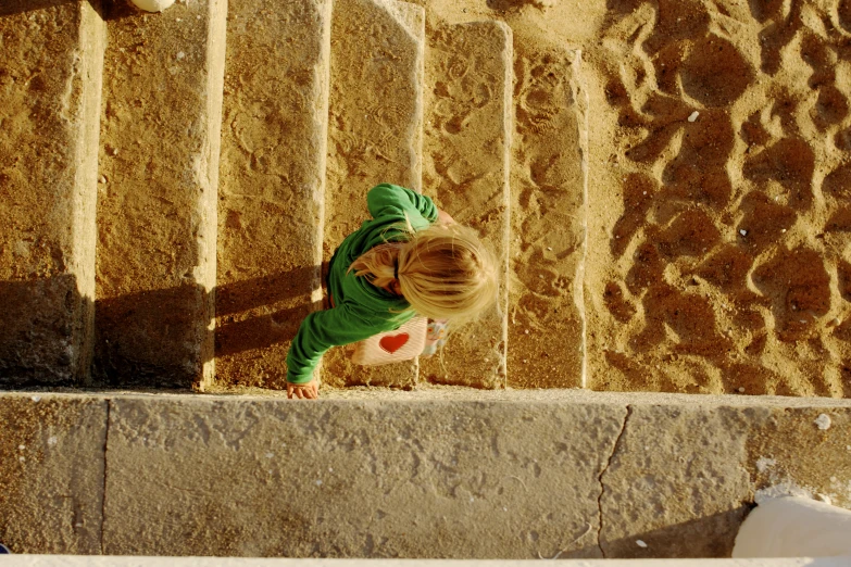 a young child standing on the outside ledge of a wall