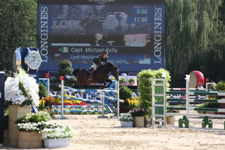 a man riding a horse jumping over an obstacle