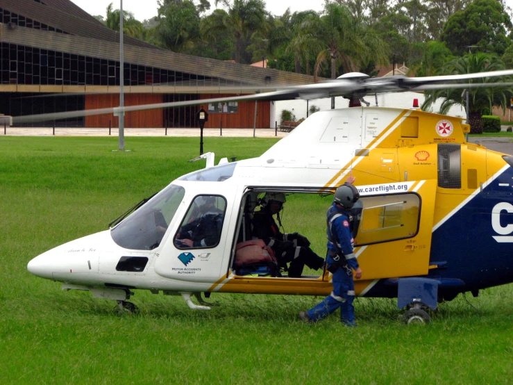 man in blue uniform loading an air ambulance into a helicopter