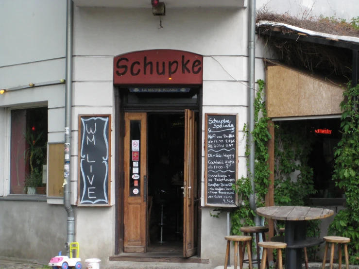 the outside of a restaurant with two tables