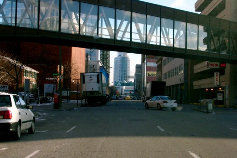 a street view of some cars under a bridge