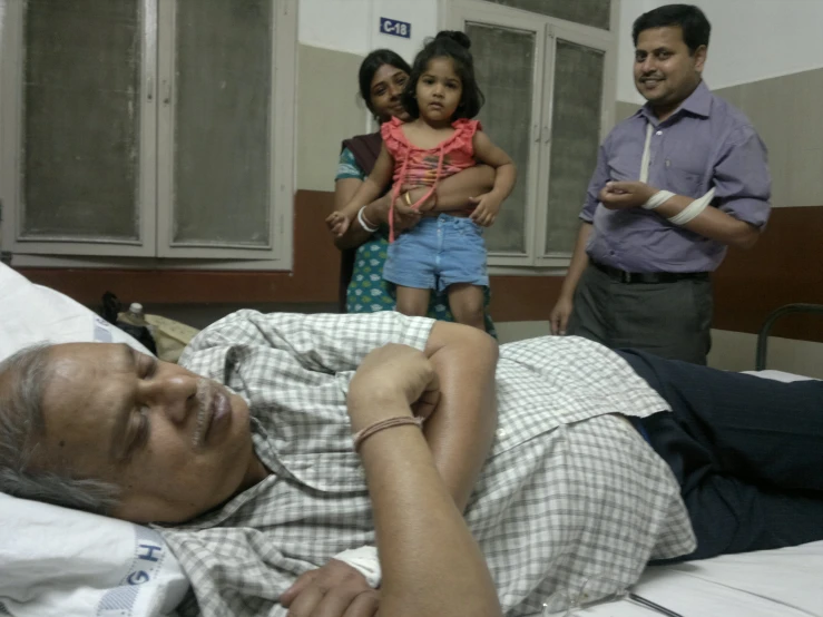 a man laying on a bed with children around him