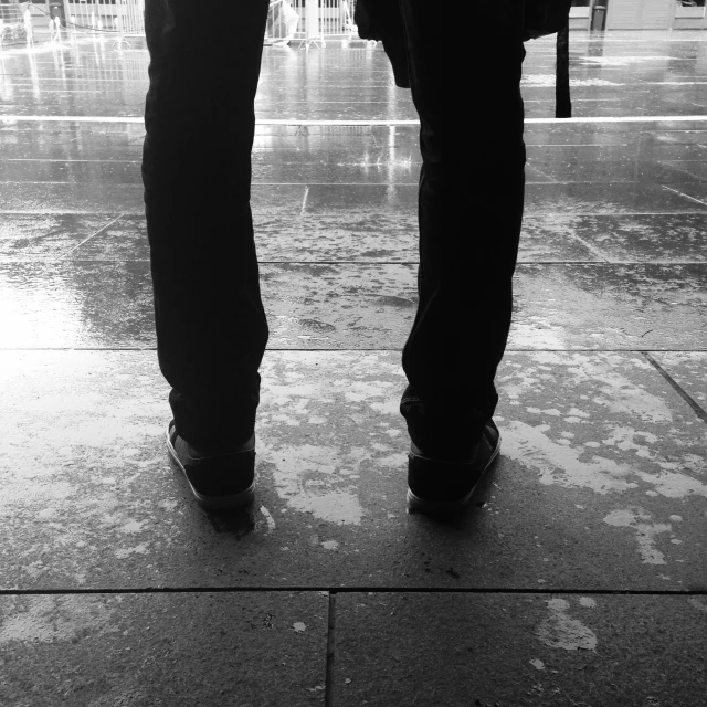 pair standing with umbrella at top of stairs