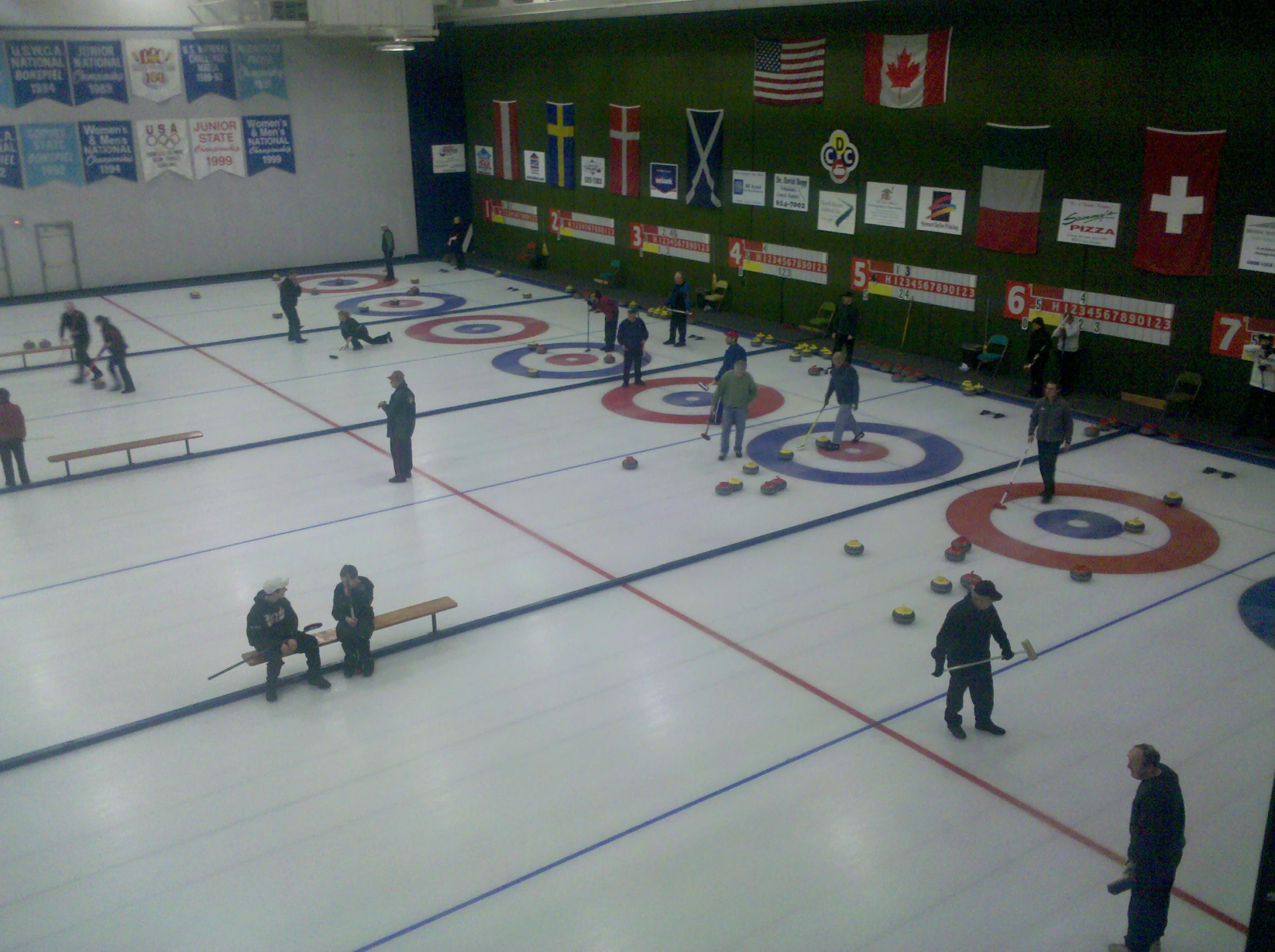 a couple of men playing curling in an indoor curling rink