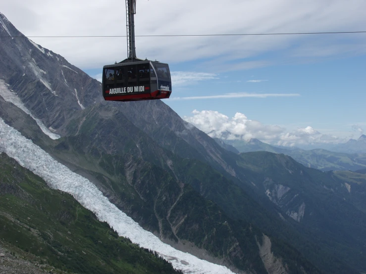 a trolly car that is hanging over mountains