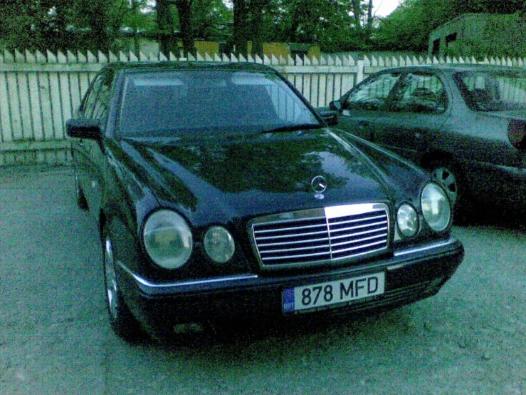 two black mercedes benzs are parked in a parking lot