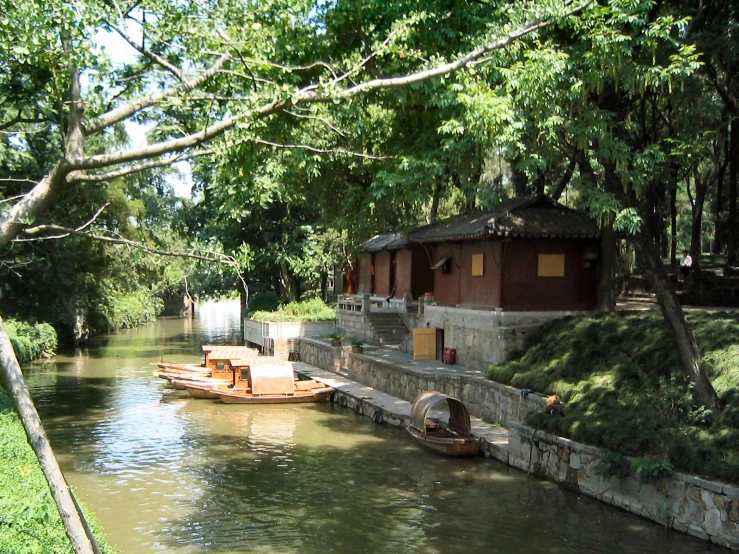 a small boat going down a river with buildings on the other side