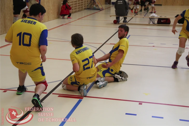 men with yellow jerseys are sitting on the floor