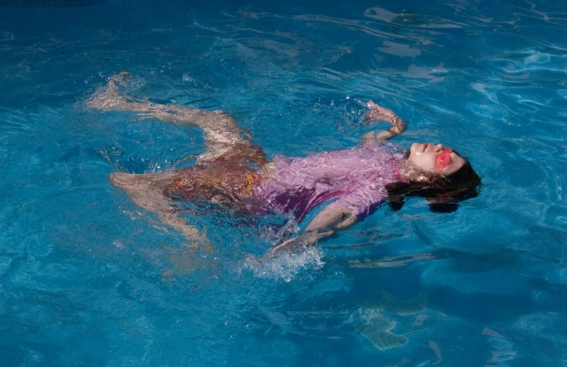 woman in pink shirt swimming in blue water