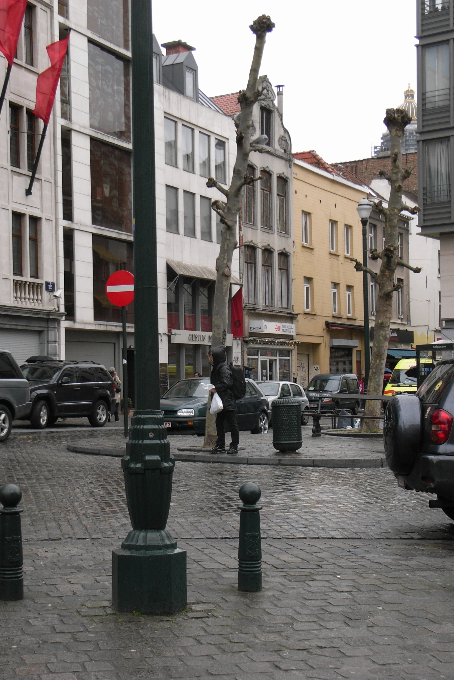 pedestrians walking down an urban cobblestone street