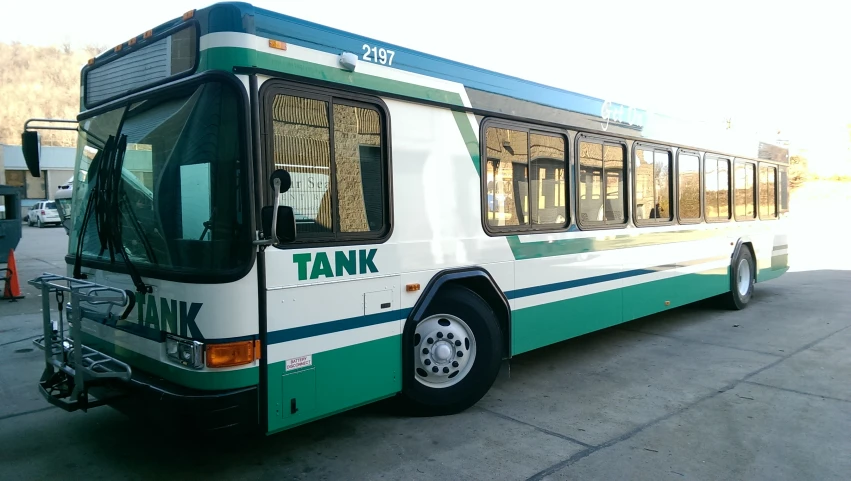 a transit bus with a loading platform sits in front of some buildings