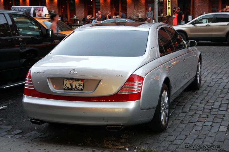 a silver car is parked on a brick street