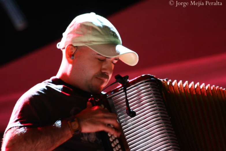 a man playing an instrument on stage with his head up