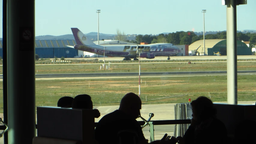 the view outside of an airport terminal from inside a window looking at a plane