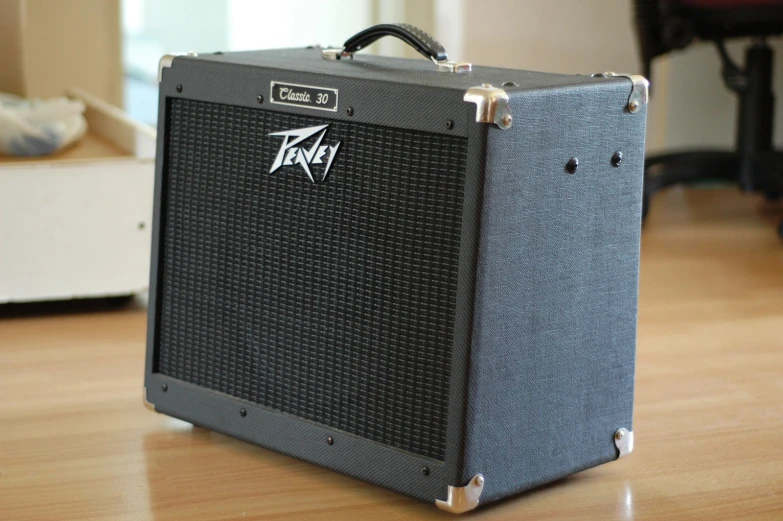 an amp with a large sticker on the front sits on a wooden table