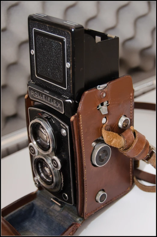 a old camera with leather case attached to a cord