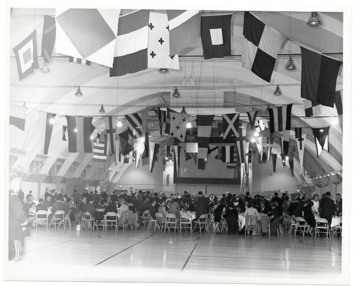 a large room with flags in the air and some people sitting