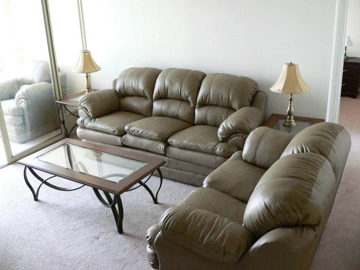 a living room with two couches, and a glass table