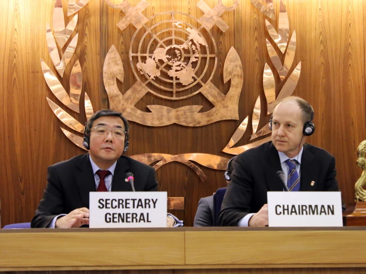 two men in business suits are at a table