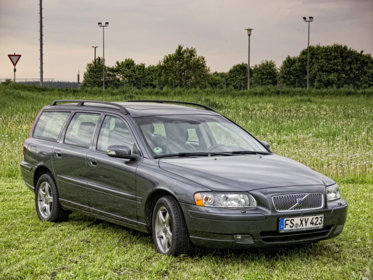 a volvo in grassy field with three lights in the background