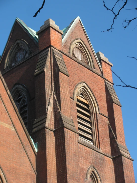 the front of a red brick church with arched windows