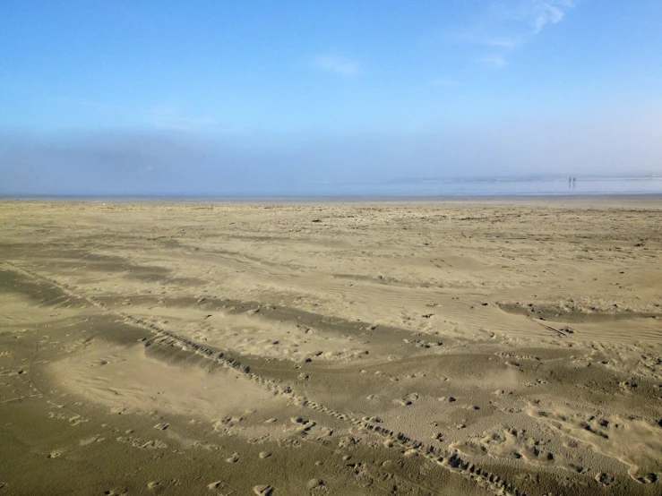 the airplane flies over the desert on the beach