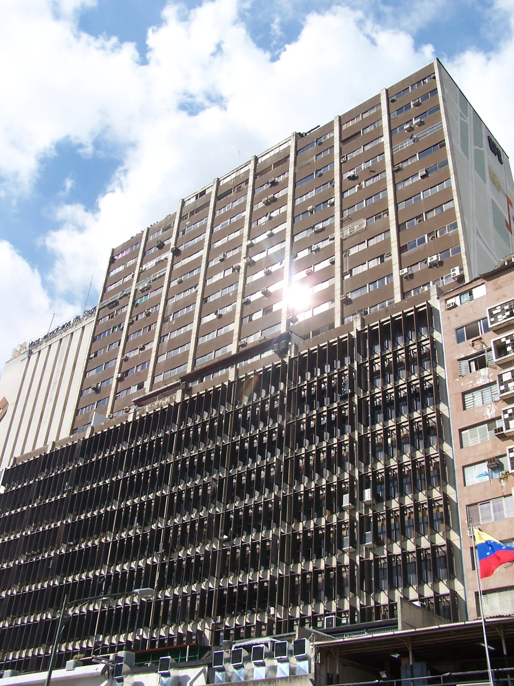 a very tall building with cars below it