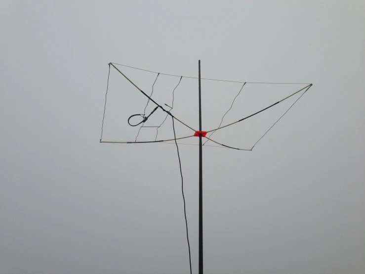 a metal antenna on the side of a large body of water