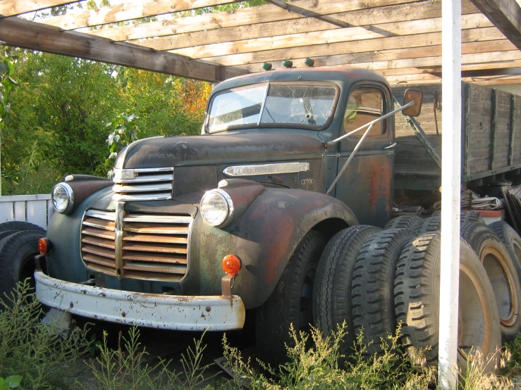 a old truck sits under an overhang