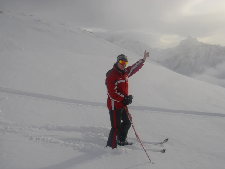 a man on skies standing at the top of a mountain