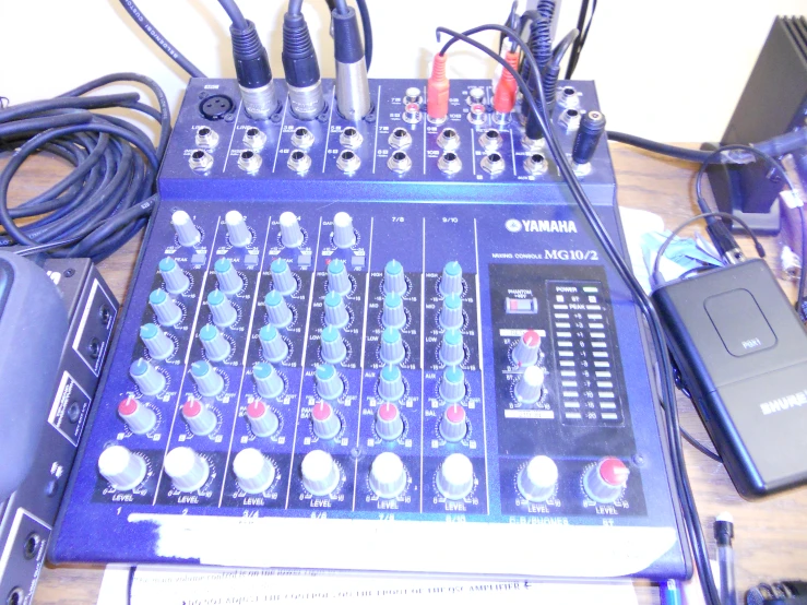 a sound mixer, microphones, and controllers are on a table