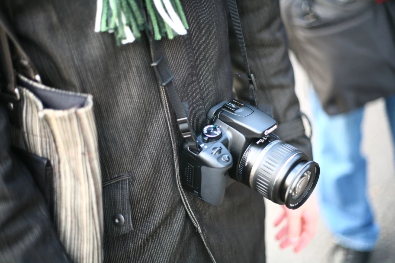 a person holding a camera in a black vest