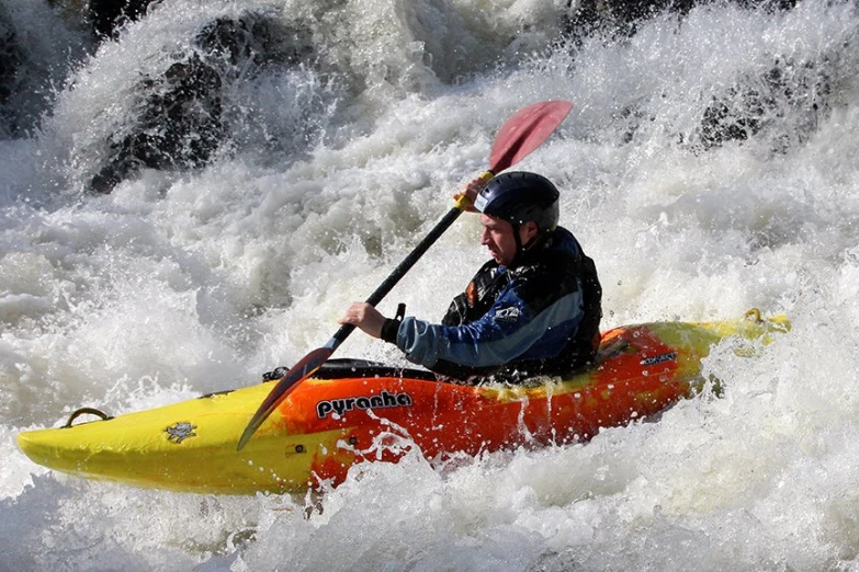 a man riding on top of a yellow kayak