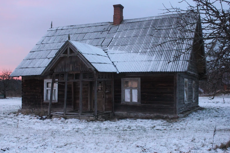 an old run down house with a lot of snow