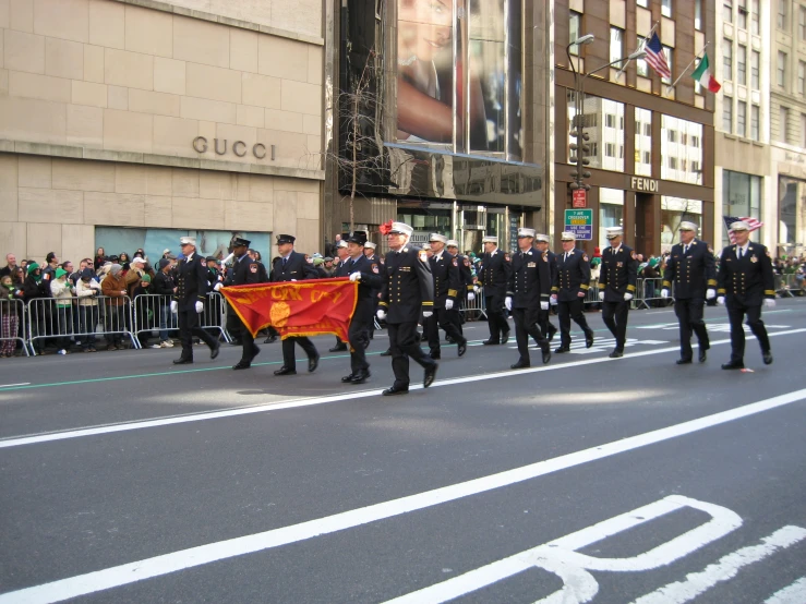 men in military uniform march in parade down the street