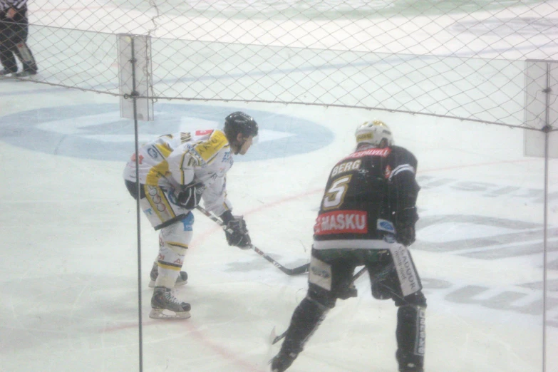 the man in yellow is trying to block the goalie