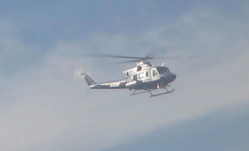 a helicopter flying through a cloudy sky