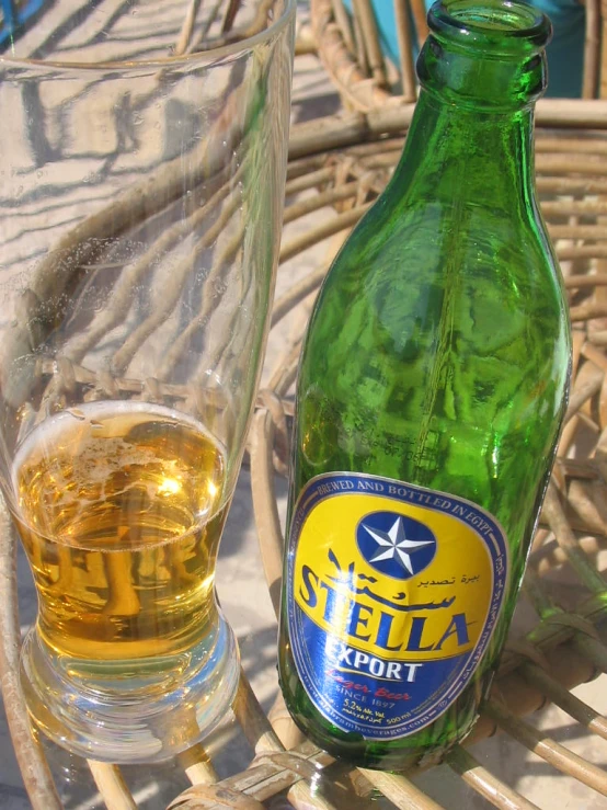 an empty beer bottle and a glass sitting on a table