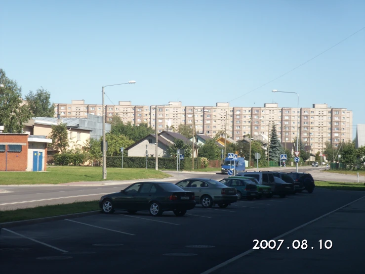 cars parked in a lot in front of buildings