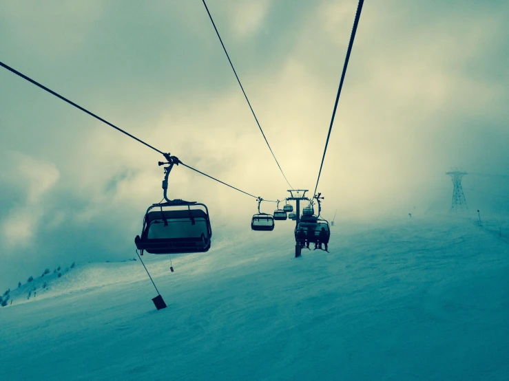 a pair of ski lifts heading up to the top of a snowy mountain