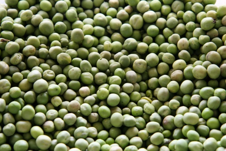 a pile of green pea's sitting side by side