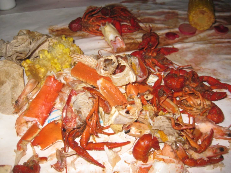 a pile of crab meat on a bed with potatoes and carrots